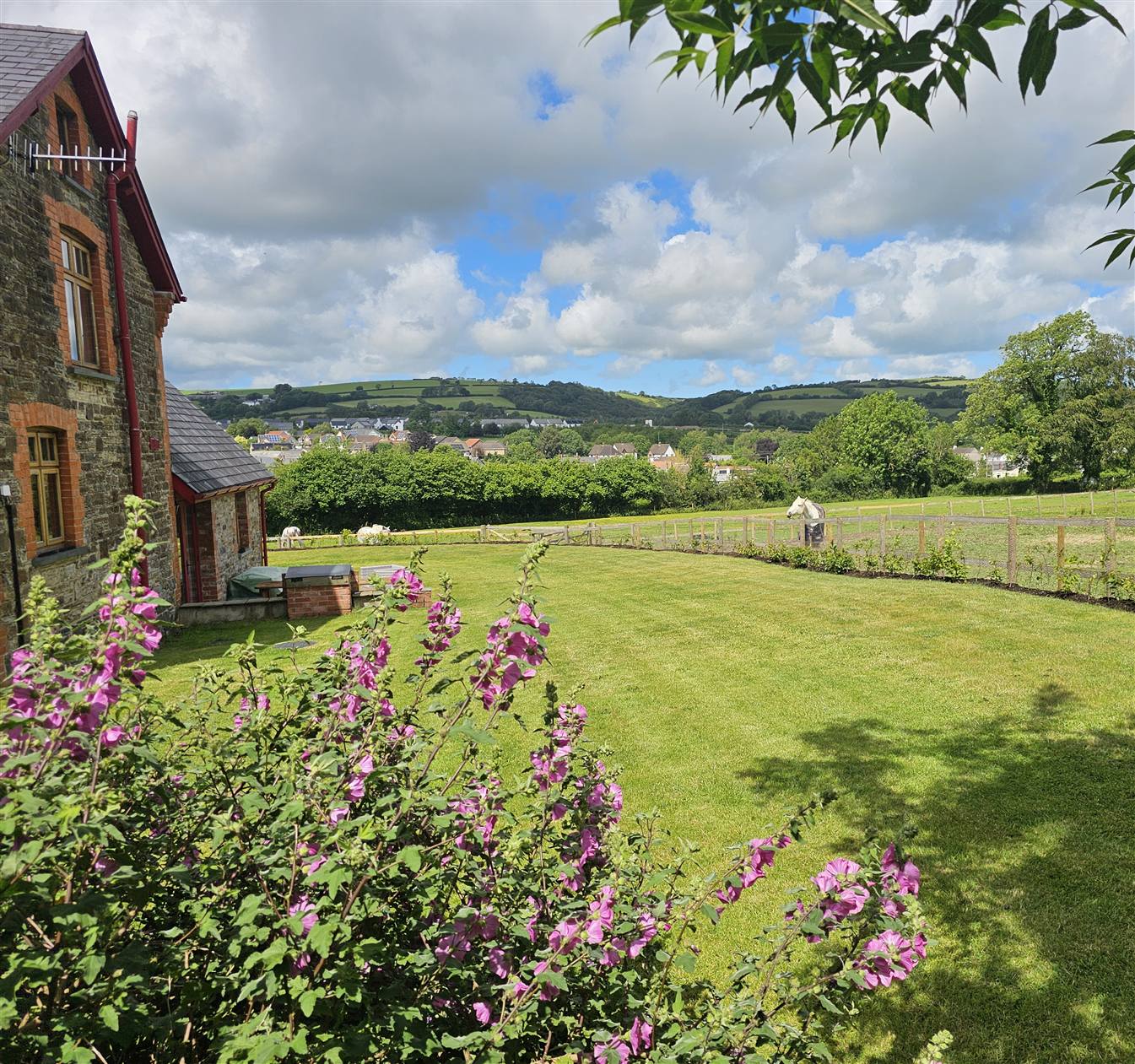 The garden beside The Granary, looking across the paddock to the village and the hills beyond
